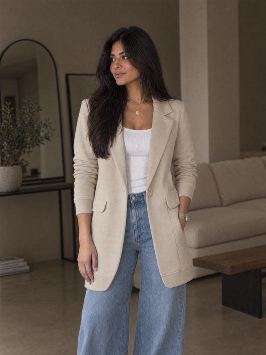 Avi wears the beige SeamFlex Blazer open over a white tank and jeans, front view