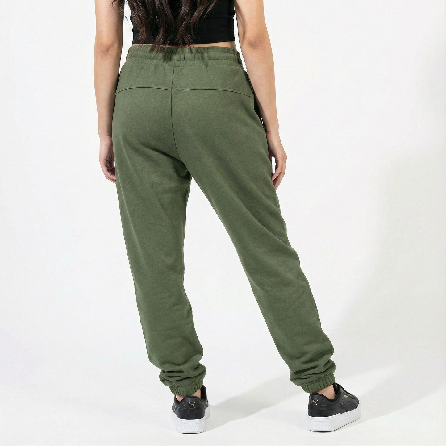 Person wearing olive green sweatpants on a white background