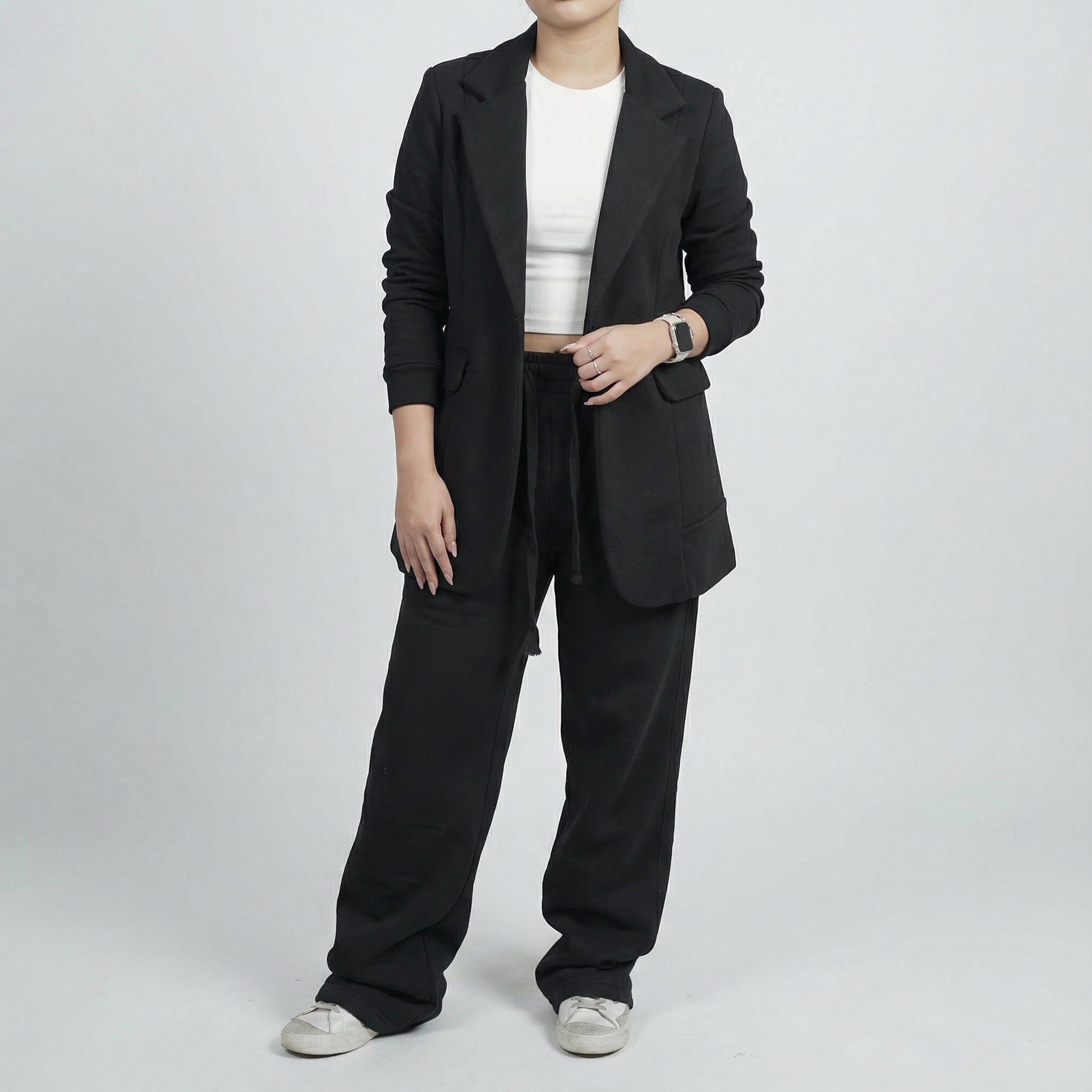 Person wearing a black suit with a white shirt on a light gray background