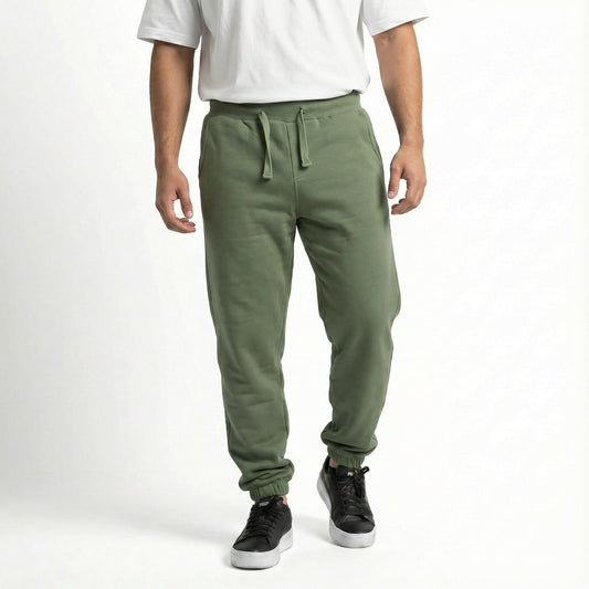 Person wearing green jogger pants and a white shirt on a white background