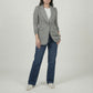 Person wearing a gray blazer and blue jeans on a plain background